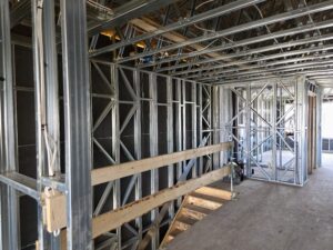 This second floor of a Cantiro steel-framed home reveals “K” bracing within the wall cavities that provide shear engineering strength.