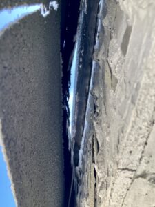 Post-burn, the EIFS lamina and mesh (left) has remained mostly unscathed. The 2-inch-thick foam has melted away, leaving a gap between the lamina and the gypsum board on the right.