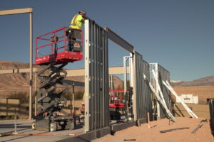 Just a few workers install prefabricated panels on a job site. Prefabricated steel-framed panels can decrease reliance on skilled labor and optimize costs. Image credit: FRAMECAD