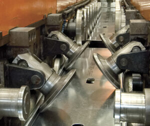 Manufacturers roll form sheet steel using progressive dies at room temperature to produce cold-formed steel (CFS) framing products. Image credit: SFIA