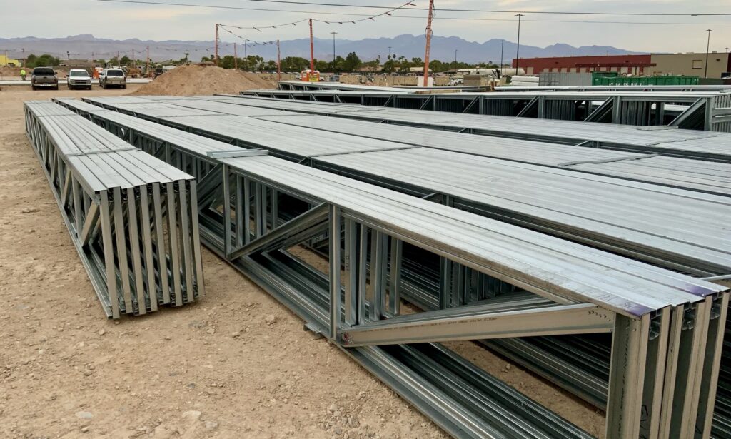 The installing contractor staged long-span cold-formed steel (CFS) roof trusses on site and ready for installation.