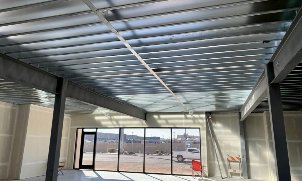 Long-span cold-formed steel (CFS) joists — a thick product with a 1200S200-68 designator — support the office mezzanines.