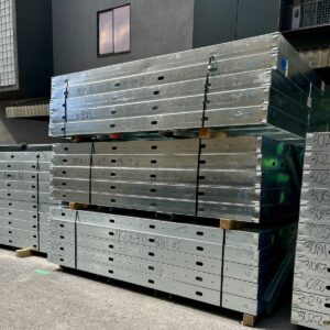 Stacks of prefabricated wall panels arrive on site, ready to be lifted into place.
