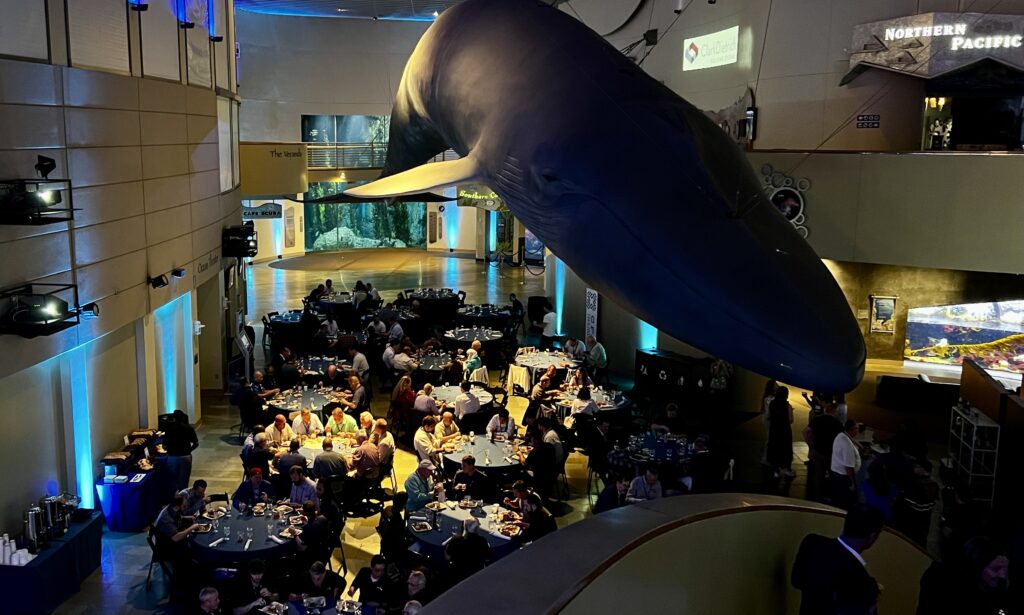 Attendees at the 2026 CFSEI Expo enjoy dinner beneath a giant blue whale and calf during an evening event at the Aquarium of the Pacific in Long Beach, California. ClarkDietrich sponsored the networking event.