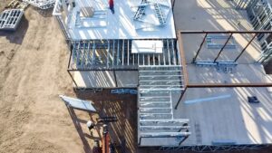 An aerial view shows how prefabricated cold-formed steel (CFS) framing integrates with structural steel systems, supporting complex architectural designs and efficient installation.